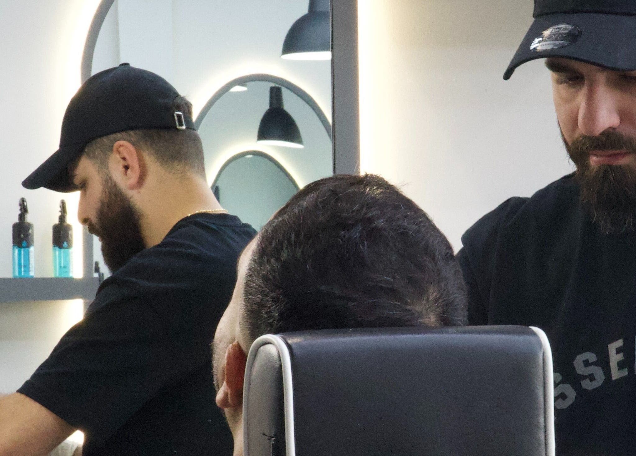 Barbers styling a client at House of Cuts in Vaughan, Ontario, CA showcasing skilled haircut techniques.