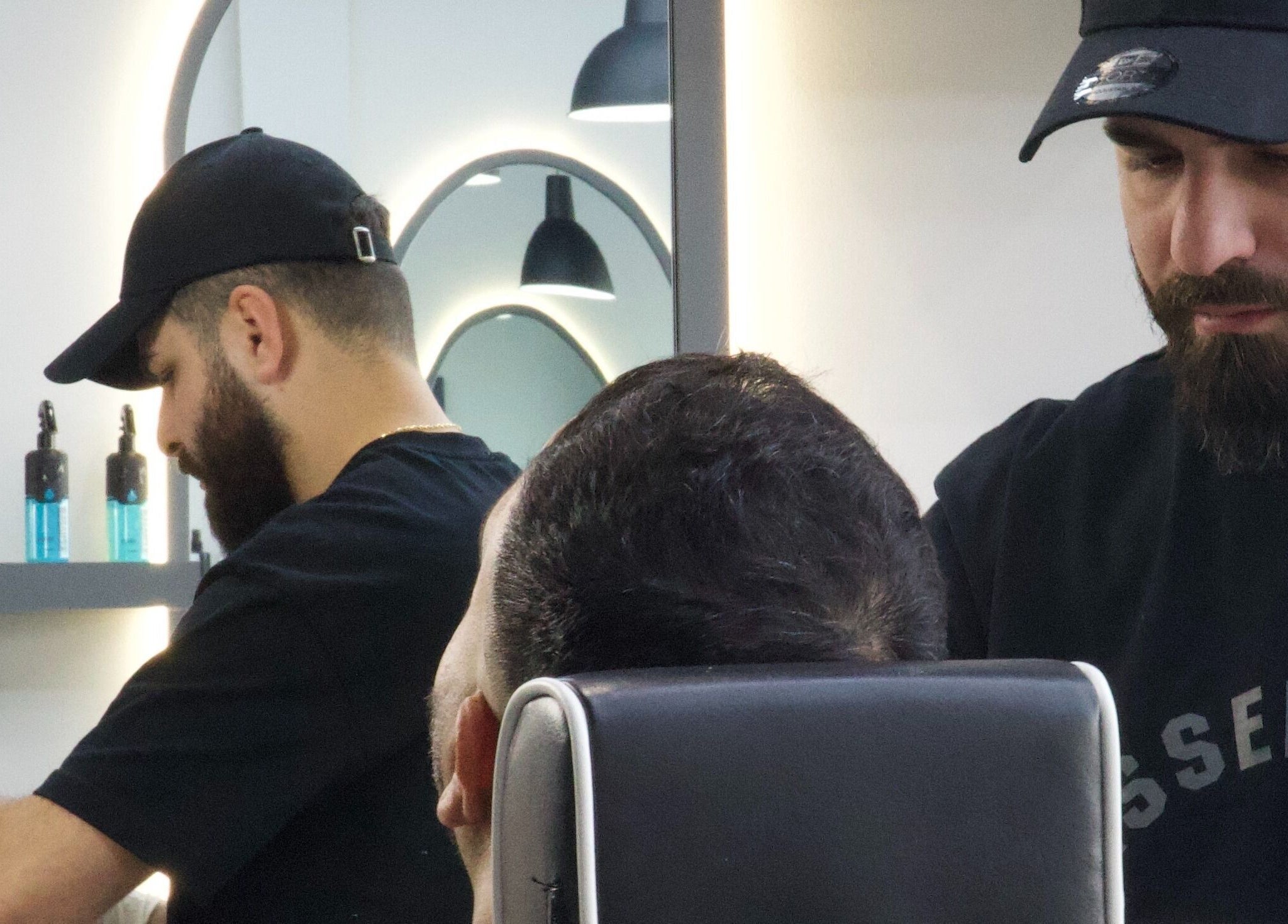 Barbers styling a client at House of Cuts in Vaughan, Ontario, CA showcasing skilled haircut techniques.