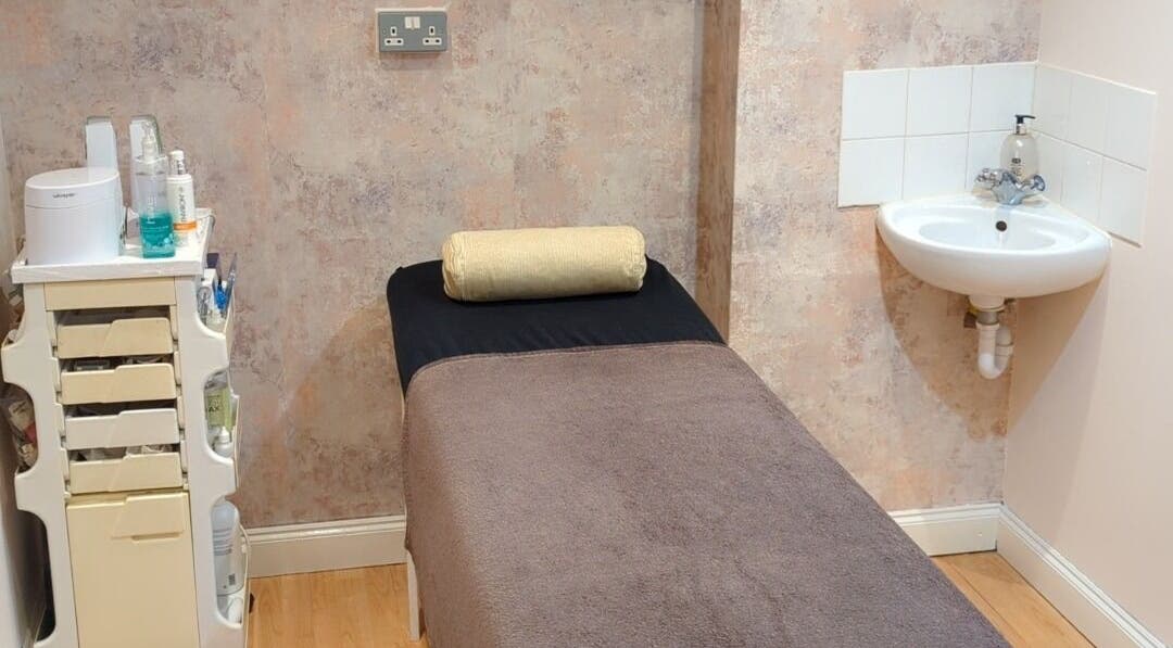 Cozy treatment room at Sandra's Beauty in London, England, GB with spa bed and sink for relaxing therapies.