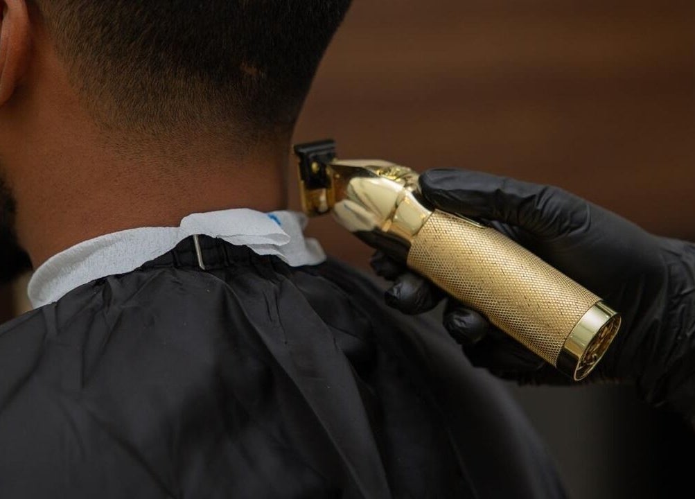 Professional haircut in Lujo Barbershop, Al Khobar, Eastern Province, SA with a golden clipper.