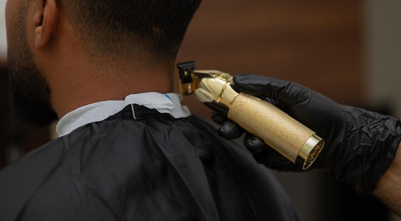 Professional haircut in Lujo Barbershop, Al Khobar, Eastern Province, SA with a golden clipper.