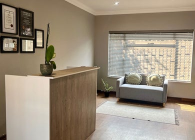Reception at Haze Aesthetics, Centurion, Gauteng, ZA, showcasing awards, comfy seating, and modern decor.
