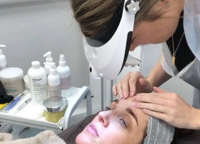 Aesthetician performs facial treatment at Skin by Cassie, Westhoughton, England, GB. Skincare products in view.