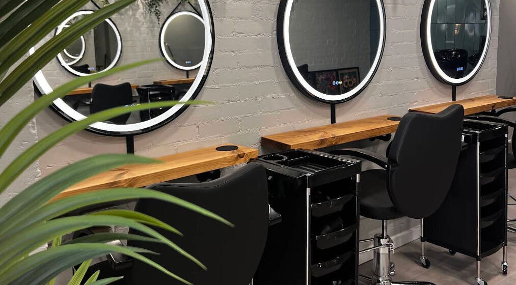 Stylish salon interior at Bobo Hair Lounge, Plymouth, England, GB with round mirrors and sleek black chairs.