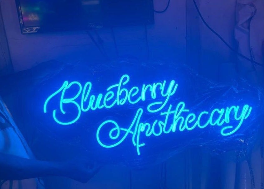 Blue neon sign displaying 'Blueberry Apothecary' at Blueberry Locs, Lekki, Lagos, NG.