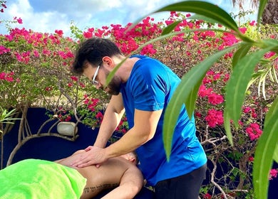 Outdoor massage at Bahia Relaxation Spa & Massage Curaçao, Willemstad, Curaçao, CW with vibrant flowers.