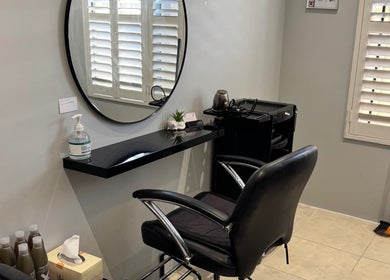 Elegant salon station at Awhair, Yanchep, Western Australia, AU, featuring sleek chair and mirror.