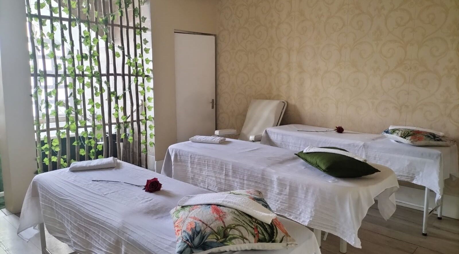 Massage beds in a tranquil room at HEAVEN ON EARTH DAY SPA, Berea, Kwazulu-natal, ZA, adorned with roses.