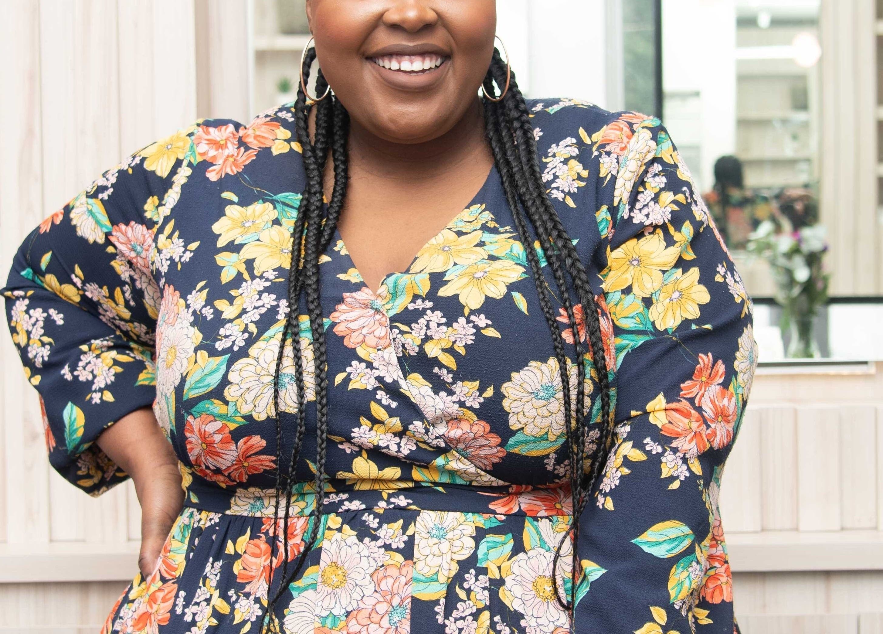 Smiling woman in floral dress at Redifine Beauty Studios, Sandton, Gauteng, ZA.