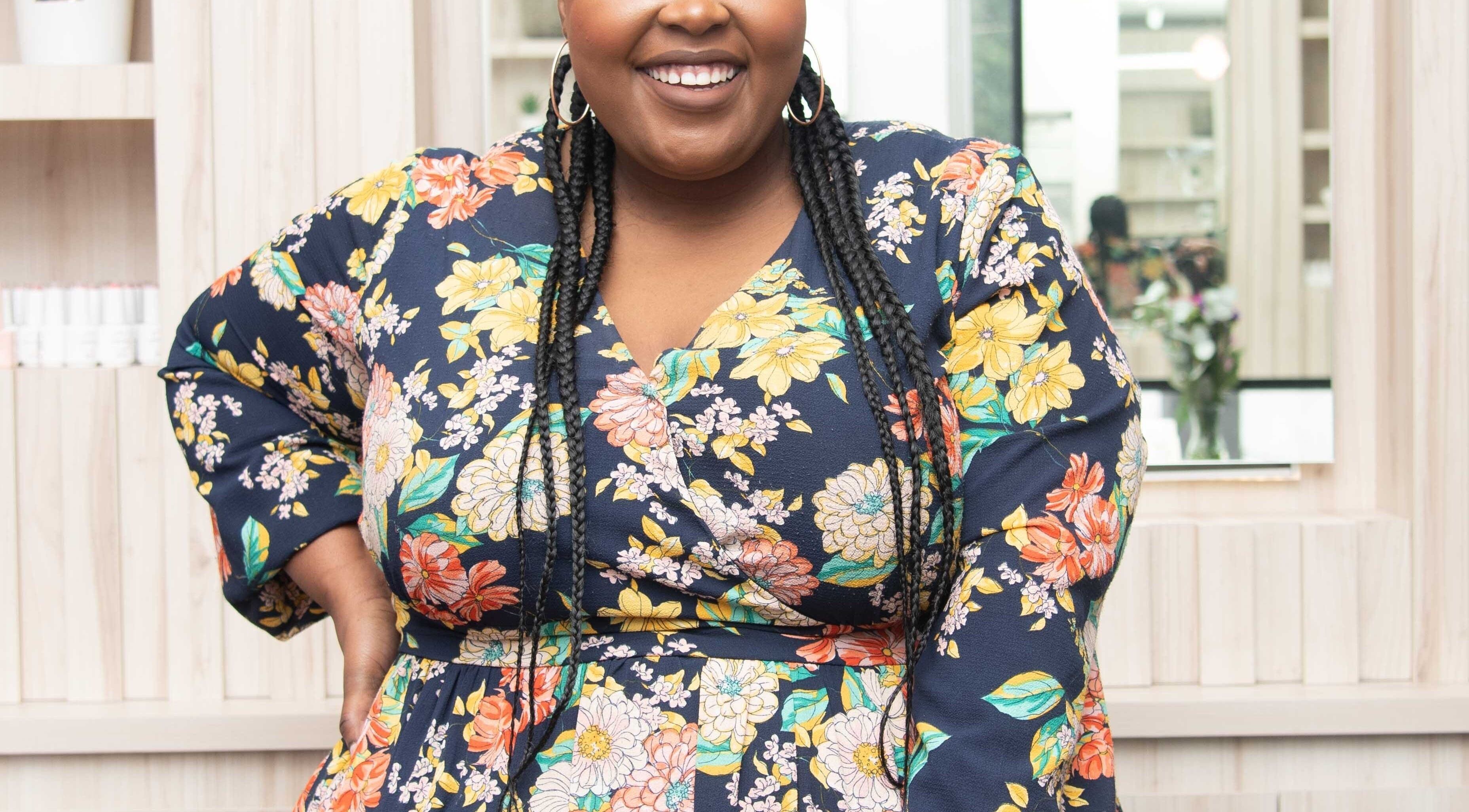 Smiling woman in floral dress at Redifine Beauty Studios, Sandton, Gauteng, ZA.
