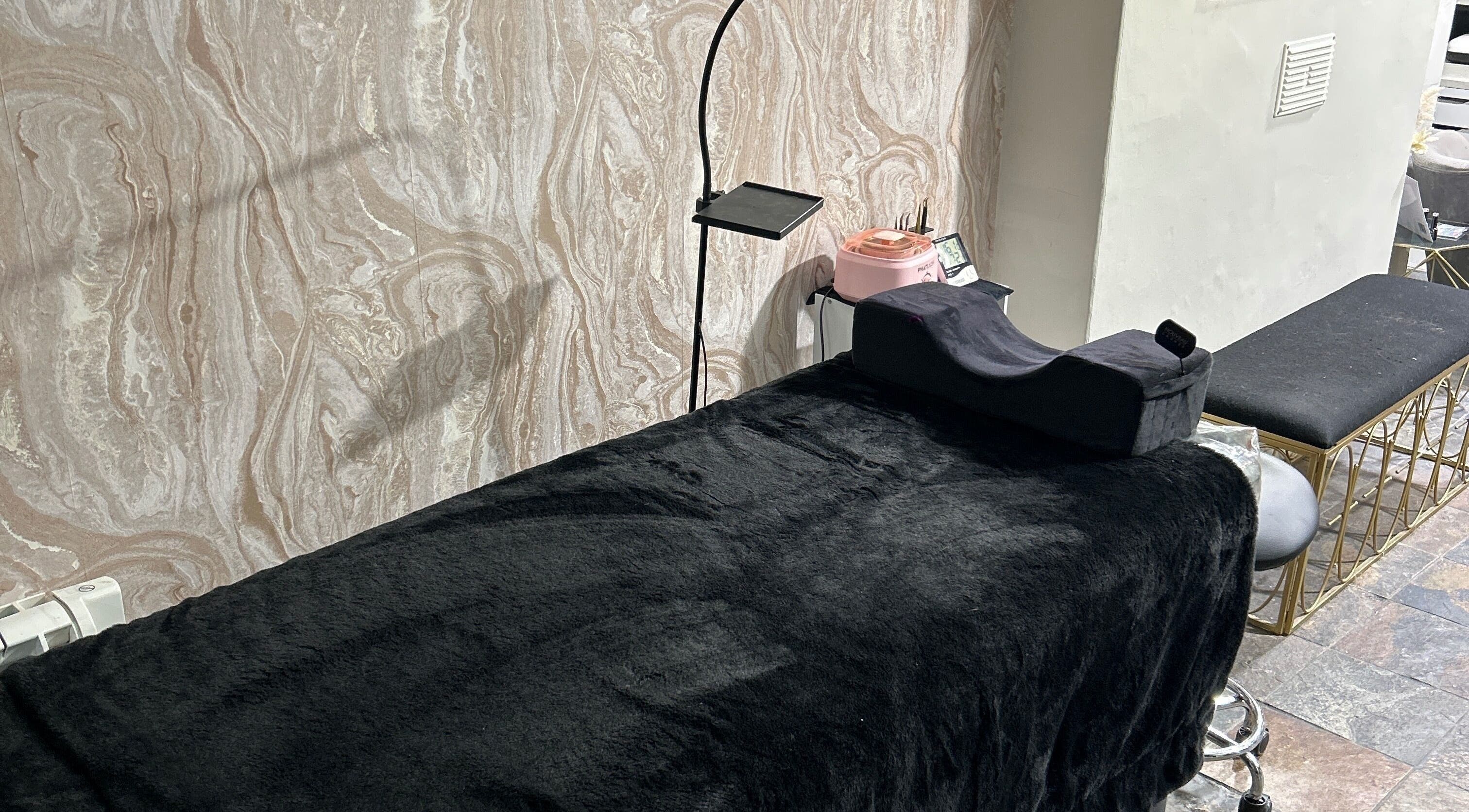 Relaxing treatment room at JMBeauty in Brayton, England, GB with a plush black massage table.