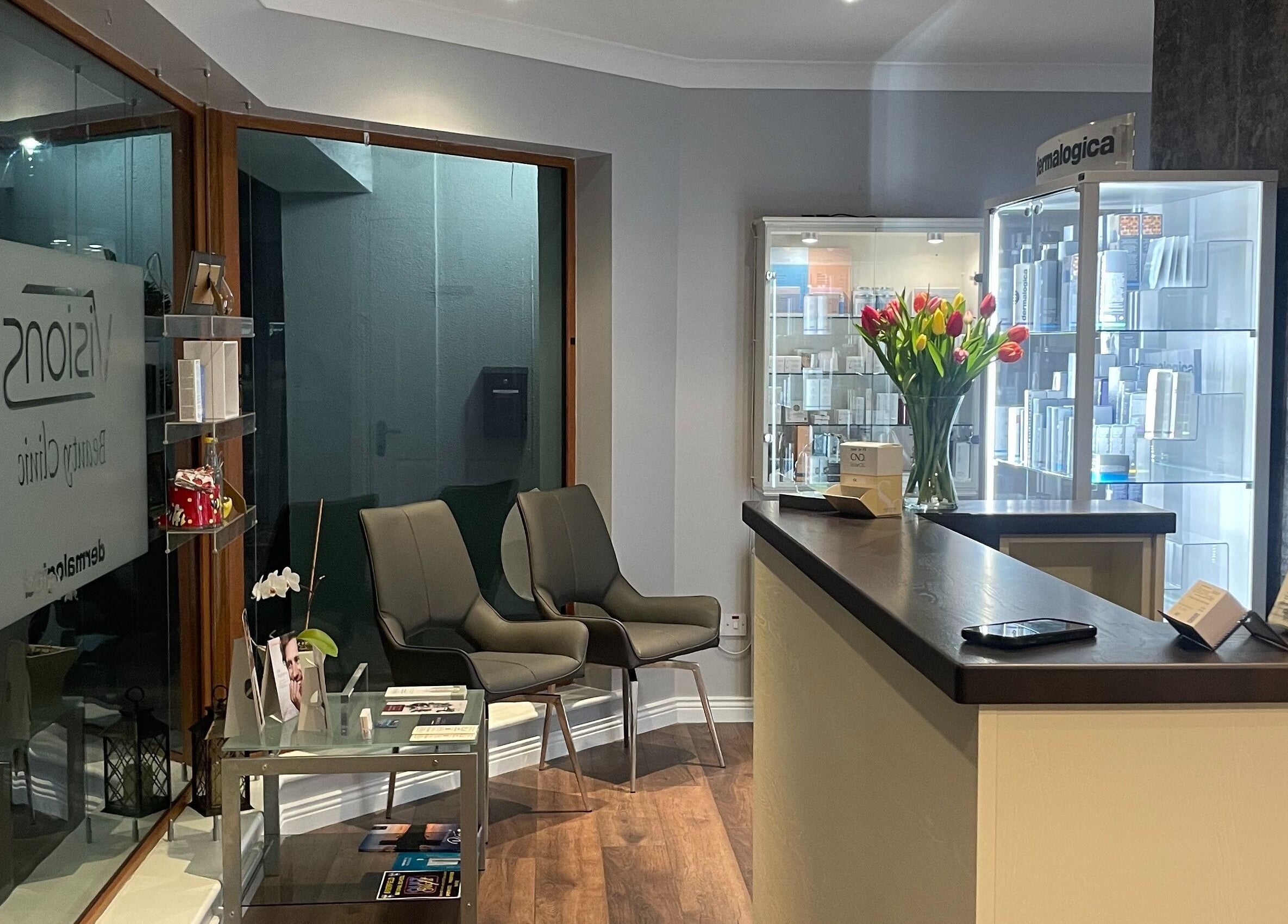 Reception area of Visions Beauty Clinic in Galway, County Galway, IE with chairs, brochures, and tulip flowers.