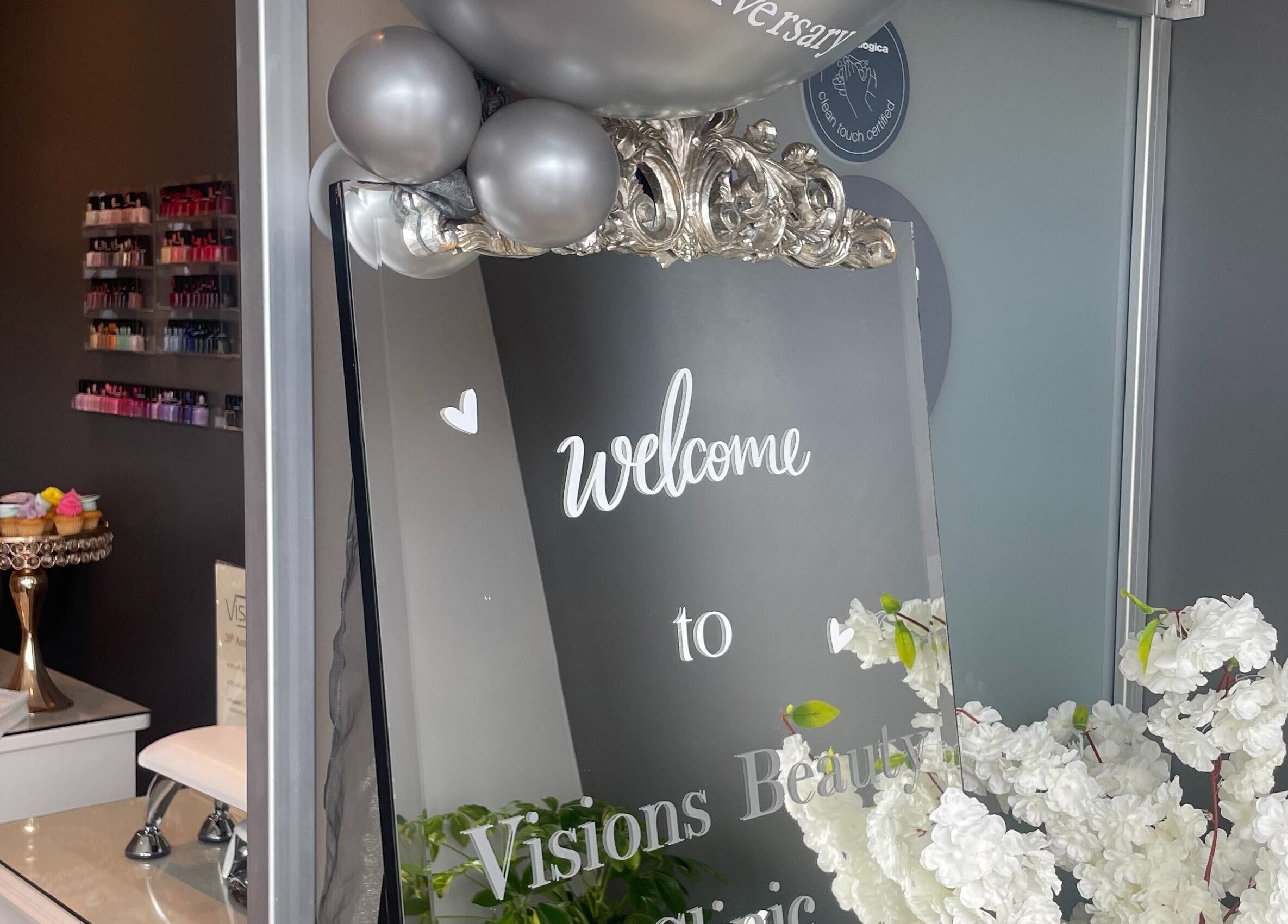 Welcome sign on mirror at Visions Beauty Clinic, Galway with elegant decor and cupcakes, enhancing ambiance.