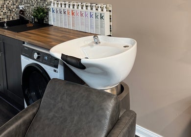 Modern hair wash station at South Beach Salon, Helston, England, GB, showcasing sleek design and premium products.