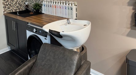 Modern hair wash station at South Beach Salon, Helston, England, GB, showcasing sleek design and premium products.