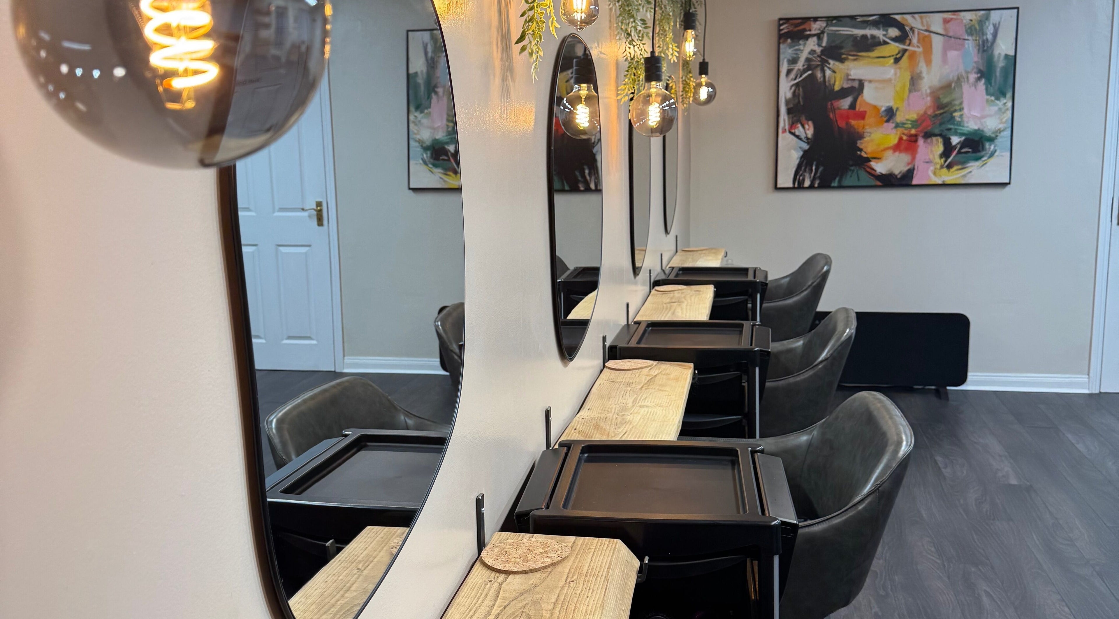 Modern salon interior at South Beach Salon, Helston, England, GB featuring stylish mirrors and sleek seating.