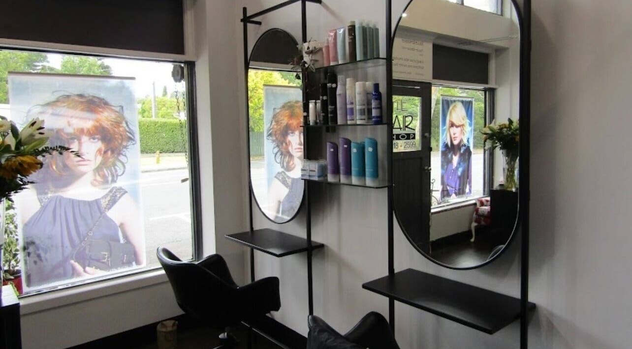 Sleek salon interior at Hair By Sarah Cook, Auckland, NZ, featuring modern mirrors and hair products.