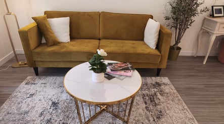 Elegant lounge area with a mustard sofa at Makeup by Inna, Edmonton, Alberta, CA.