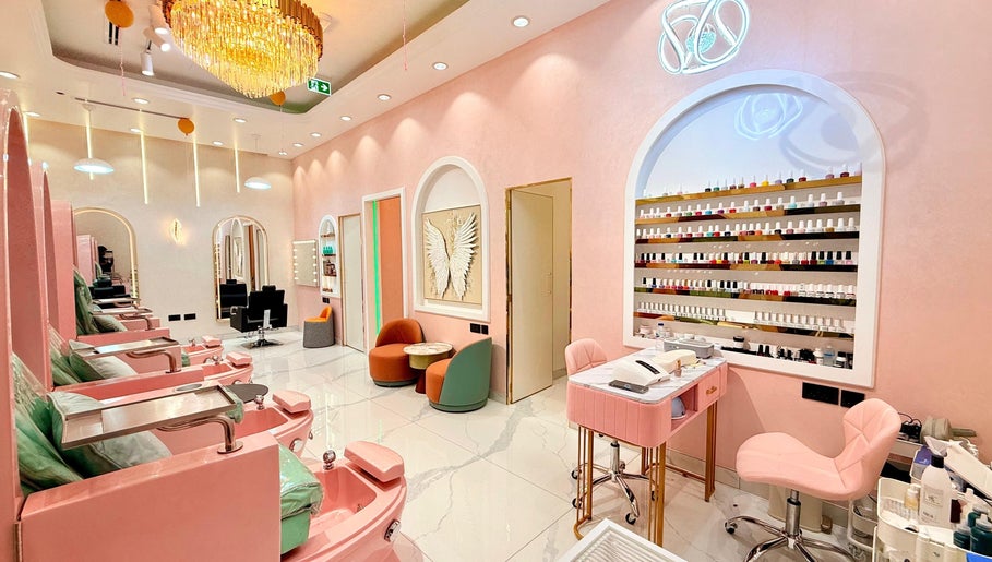 Elegant interior of Artika Beauty Lounge in Dubai, featuring plush seating and a chic nail polish display wall.