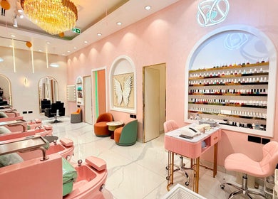 Elegant interior of Artika Beauty Lounge in Dubai, featuring plush seating and a chic nail polish display wall.