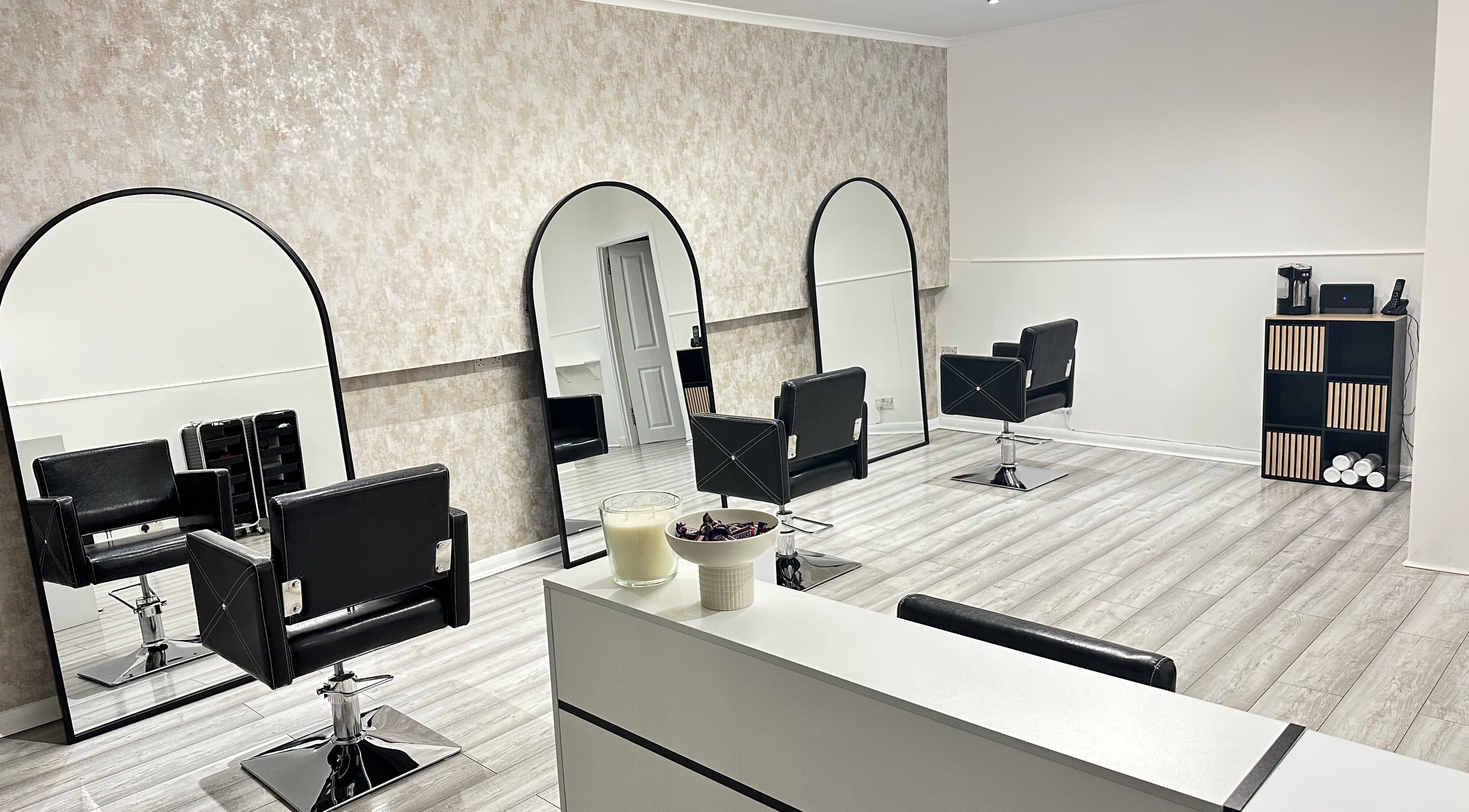 Modern interior of Luxe Hair Studio in Edinburgh, Scotland, GB, featuring sleek styling chairs and large mirrors.
