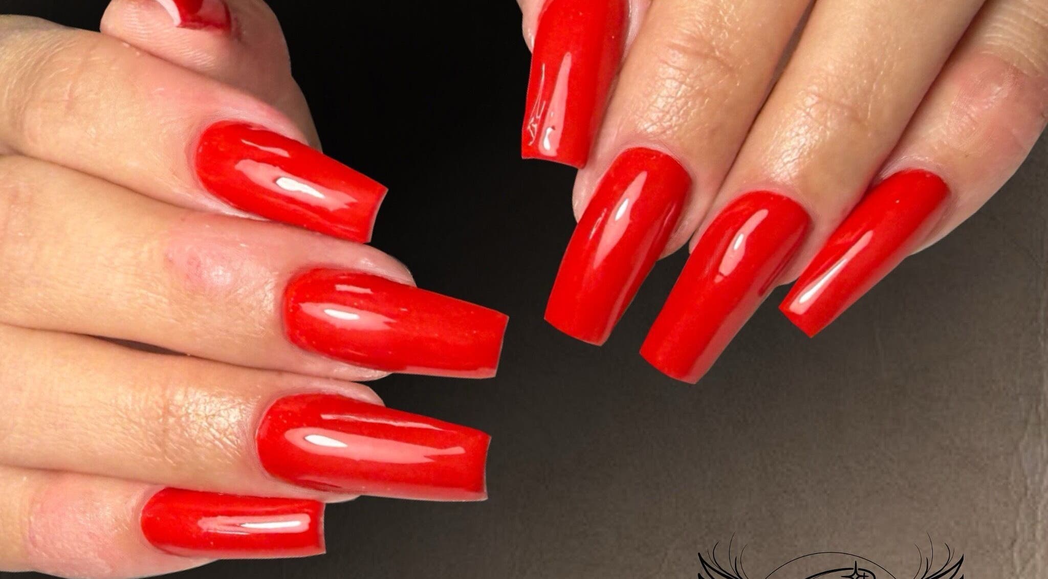 Uñas esmaltadas en rojo vibrante en Ikaros Nailash, Gijón, ES.