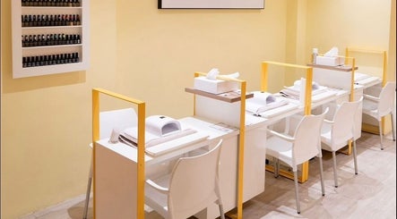 Modern nail salon at Pomegranate, Cape Town, Western Cape, ZA, featuring sleek white stations and polish display.