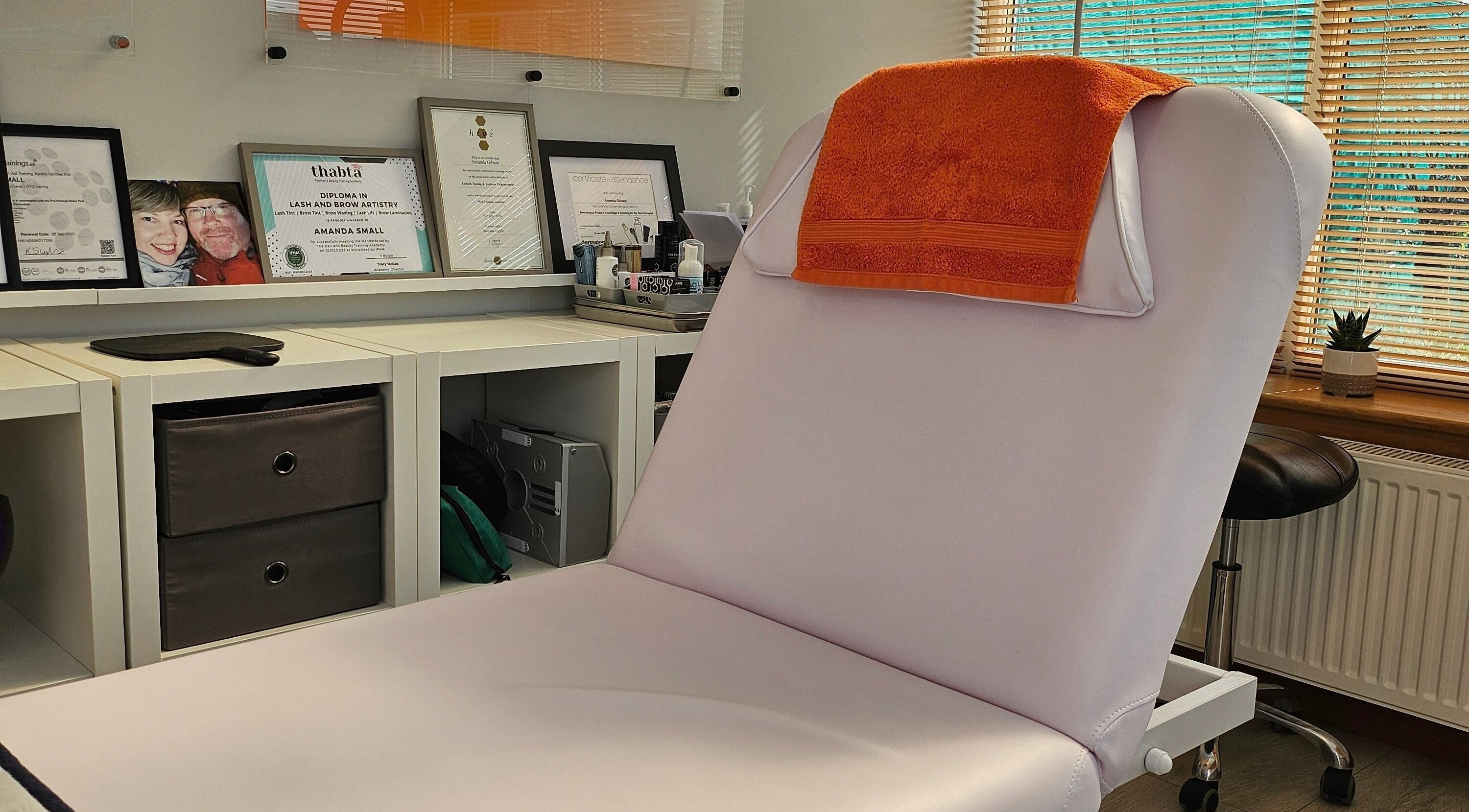 Cozy treatment room at Brow Wow and Scalp Ethic, Kirkcaldy, Scotland, GB with certificates and orange towel.