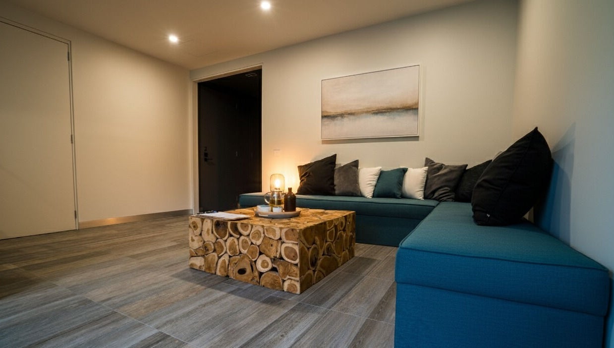 Relaxing lounge area at Innerverse Float & Wellness Southbank, Melbourne, AU featuring teal seating and a rustic table.