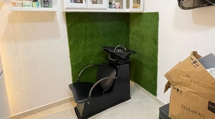 Estación de lavado de cabello en Afro Mery Beauty Center, Samaná, Samaná, DO, con pared verde decorativa.