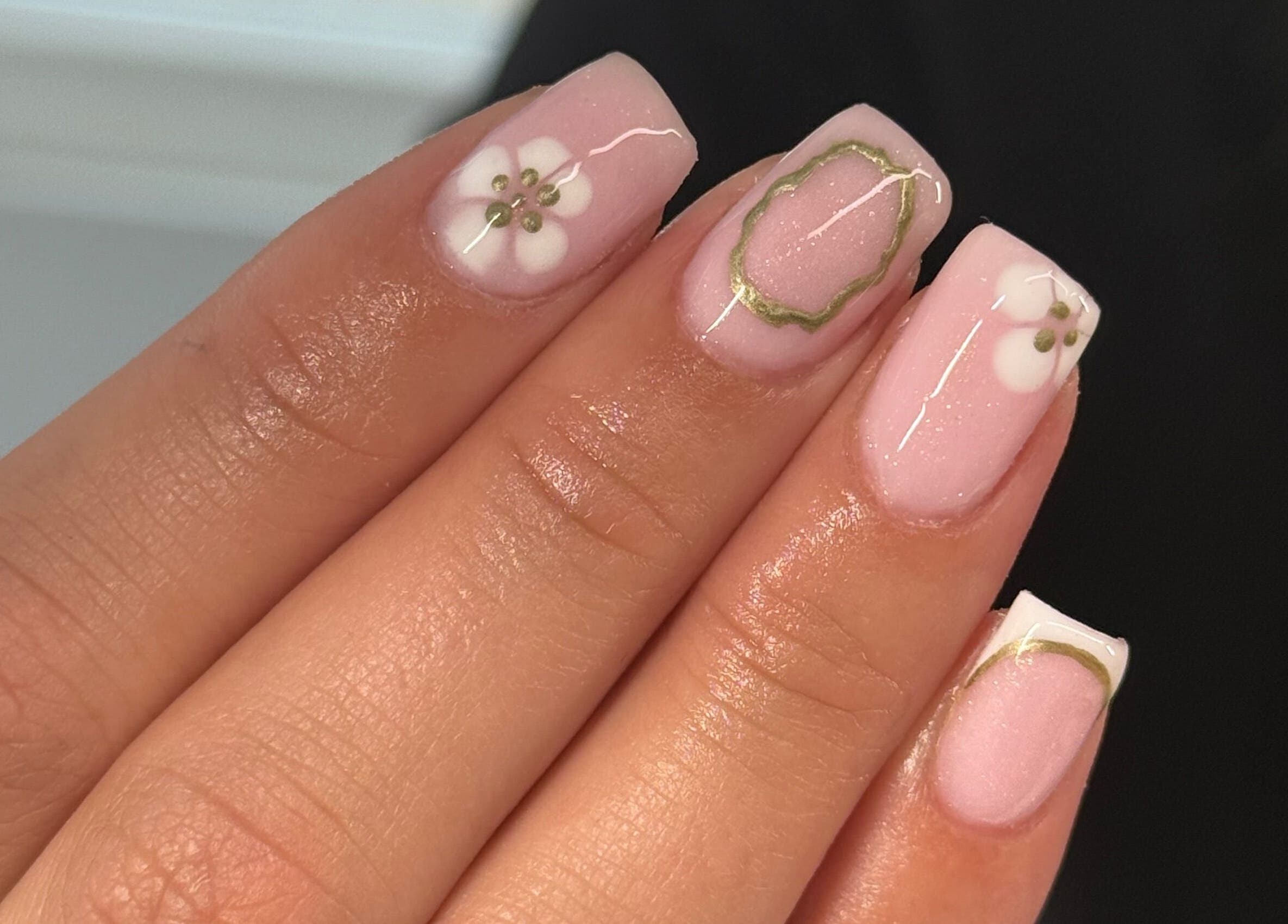 Elegant floral nail design at HJMNails, Haywards Heath, England, GB, featuring pink polish and white flowers.