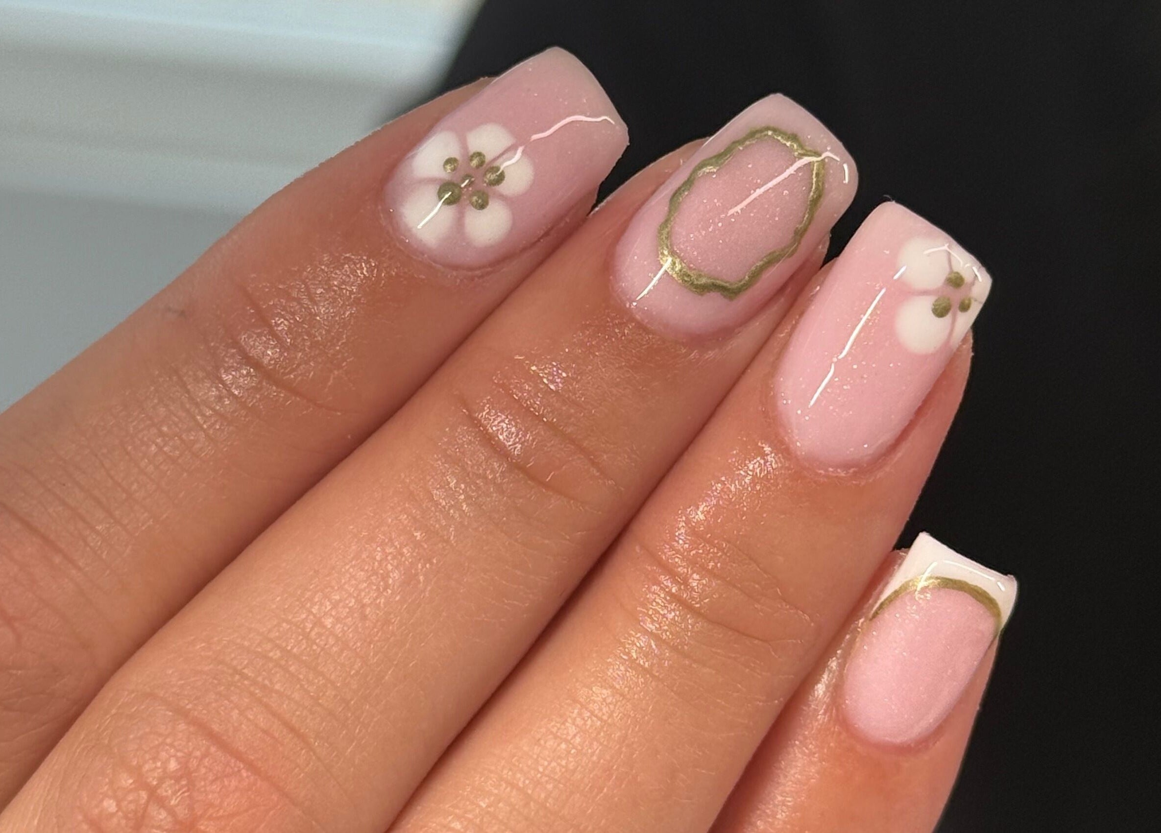 Elegant floral nail design at HJMNails, Haywards Heath, England, GB, featuring pink polish and white flowers.