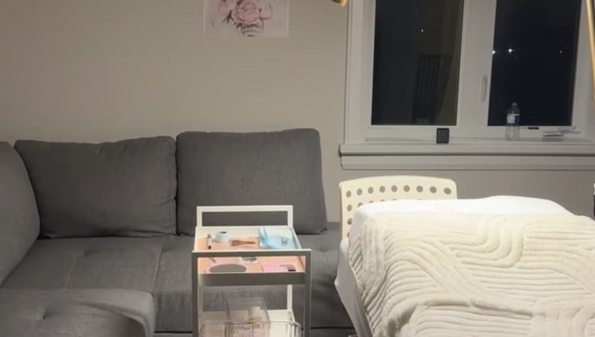 Luxurious treatment area at The Beauty Club AM (Vaughan), Vaughan, Ontario, CA, featuring a plush couch and massage bed.