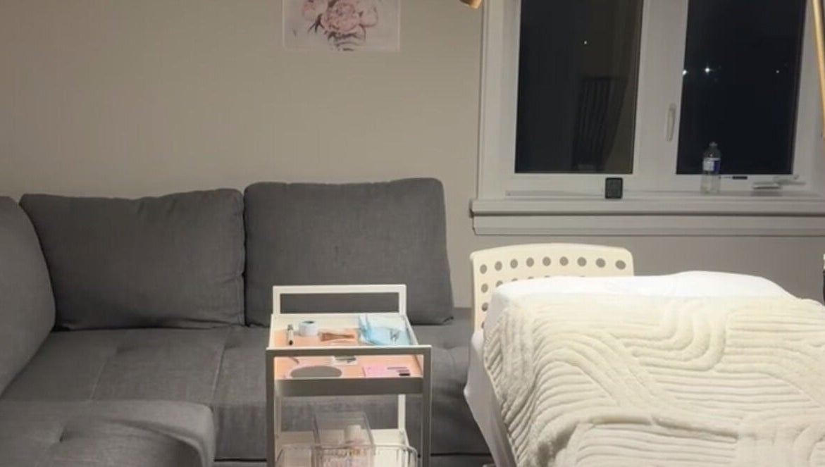 Luxurious treatment area at The Beauty Club AM (Vaughan), Vaughan, Ontario, CA, featuring a plush couch and massage bed.