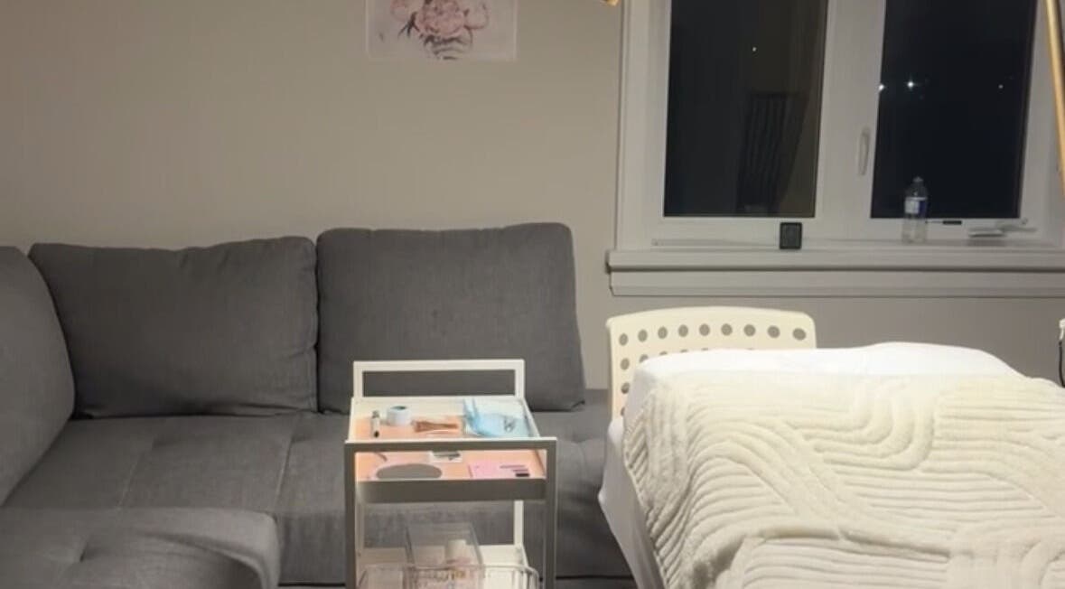 Luxurious treatment area at The Beauty Club AM (Vaughan), Vaughan, Ontario, CA, featuring a plush couch and massage bed.