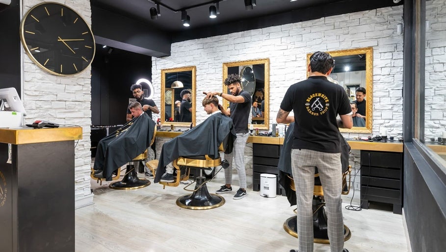 Interior moderno de barbería en Masajes sdsd, Bilbao, ES, con estilistas atendiendo clientes.