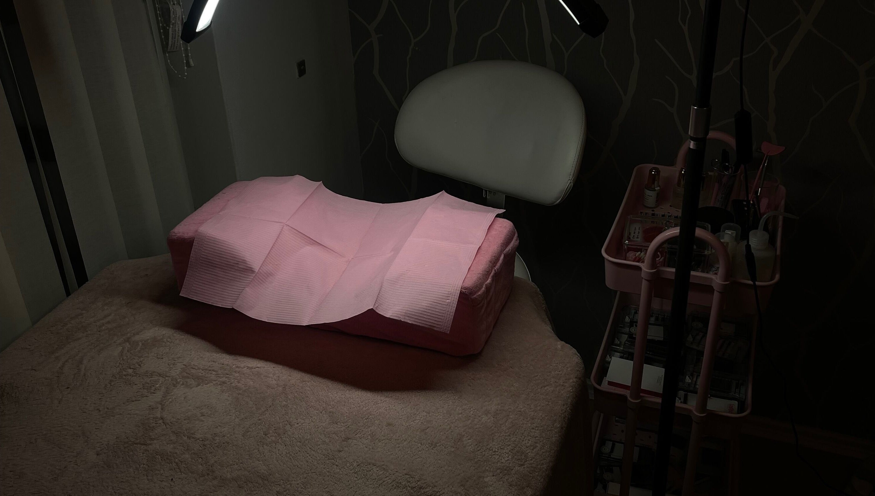 Cozy treatment room at Teeluxe Beauty, Potters Bar, England, GB, featuring a padded table and soft lighting.