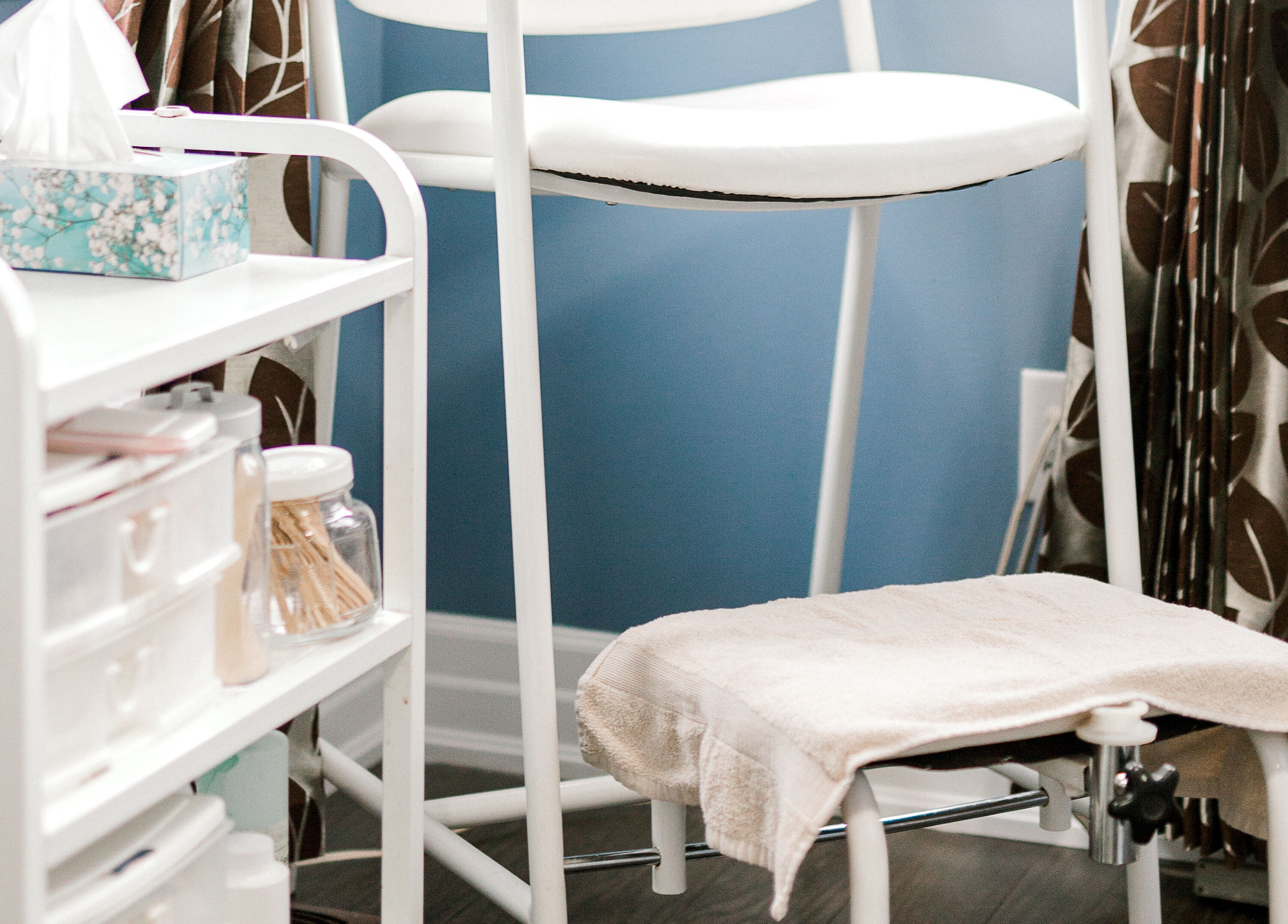 Relaxing treatment room at Rapis Secret, WATERDOWN, Ontario, CA, featuring a comfortable chair and organized supplies.