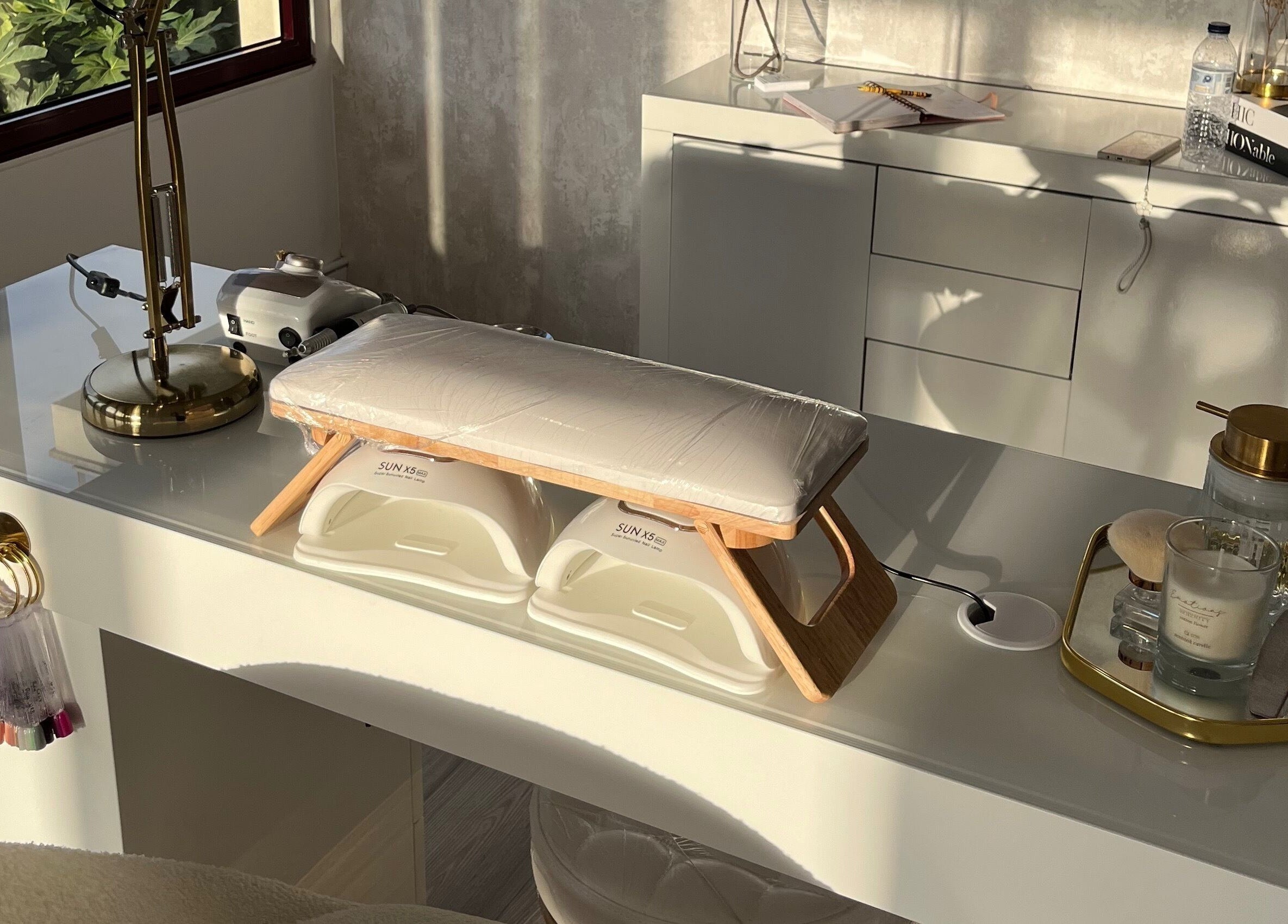 Mesa de manicure iluminada em B.EE Beauty & Wellness, Estarreja, Aveiro, PT, com lâmpada dourada e acessórios.