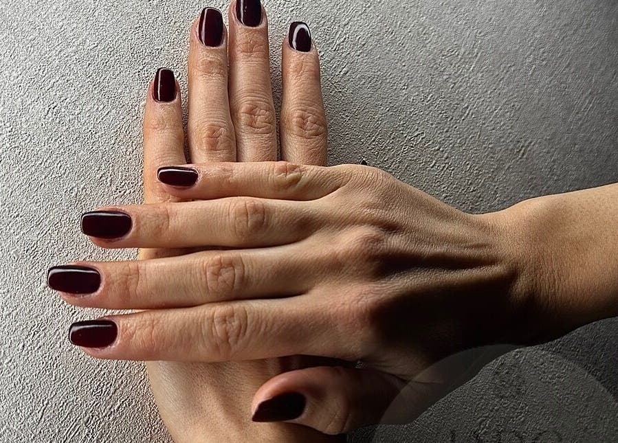 Perfekte Maniküre bei Jade Nail Studio in Frankfurt Am Main, Hessen, DE mit eleganter dunkler Nagellackfarbe.