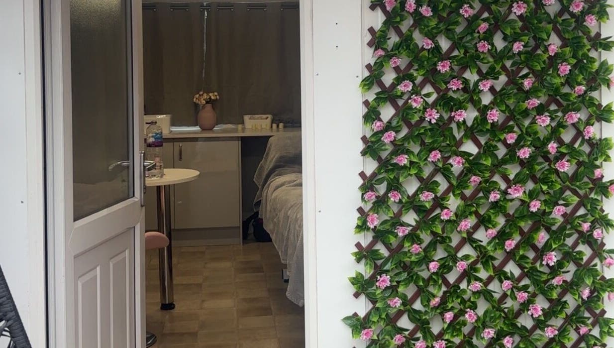 Entrance of The Glow Room in York, England with elegant floral decor on the wall.