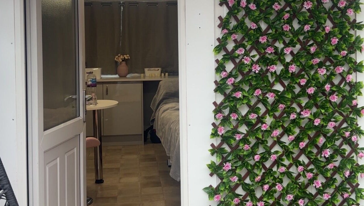 Entrance of The Glow Room in York, England with elegant floral decor on the wall.