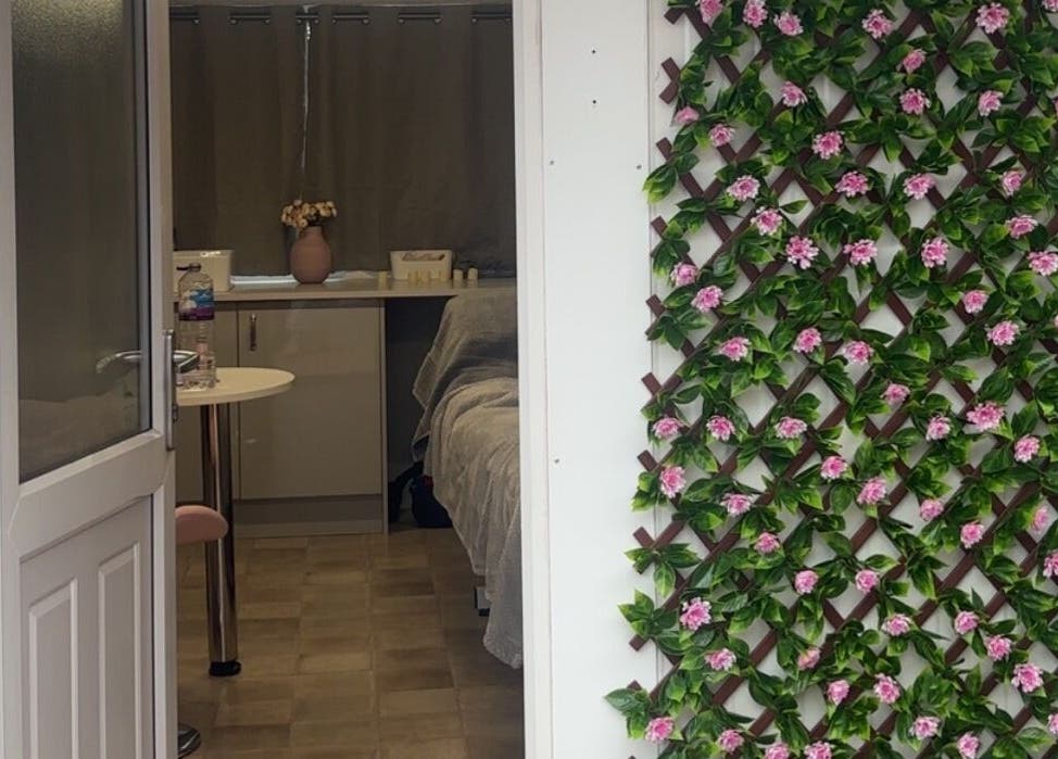 Entrance of The Glow Room in York, England with elegant floral decor on the wall.