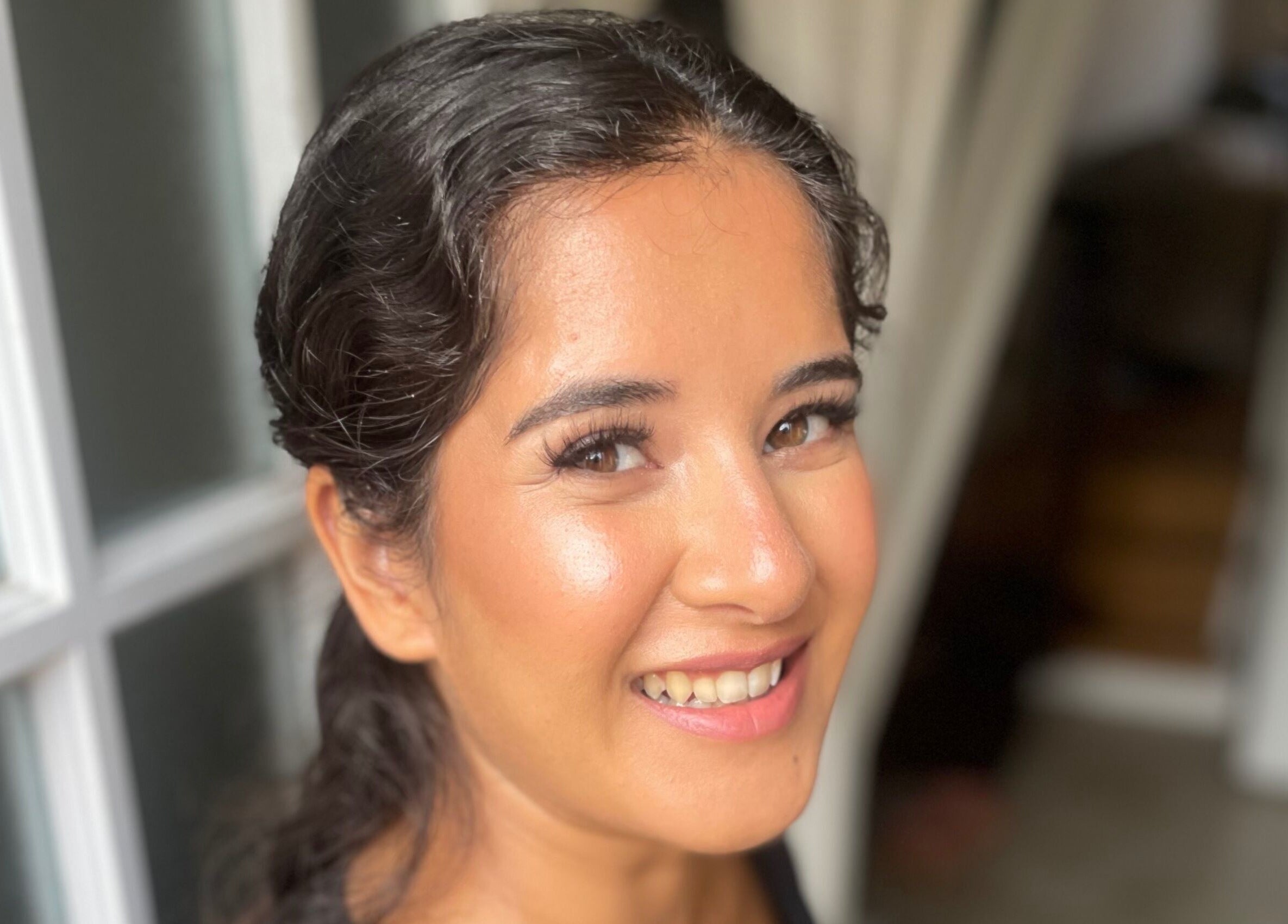 Smiling woman with glowing makeup by Lisa Critchley Makeup Artist in Abbots Langley, England, GB.