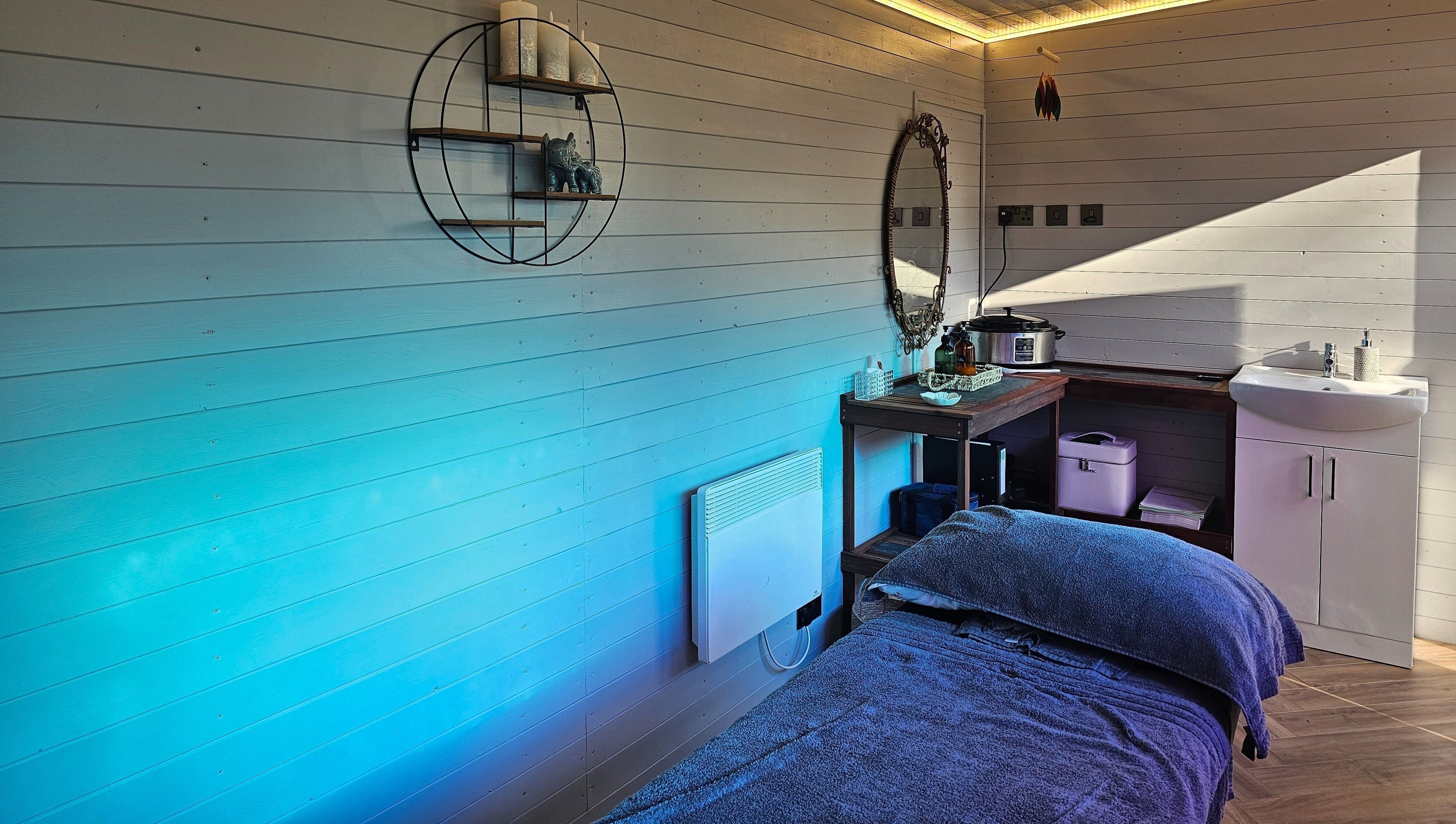 Relaxing massage room at Jem Stones Holistic Massage in Swindon, England, GB, featuring soothing blue tones.