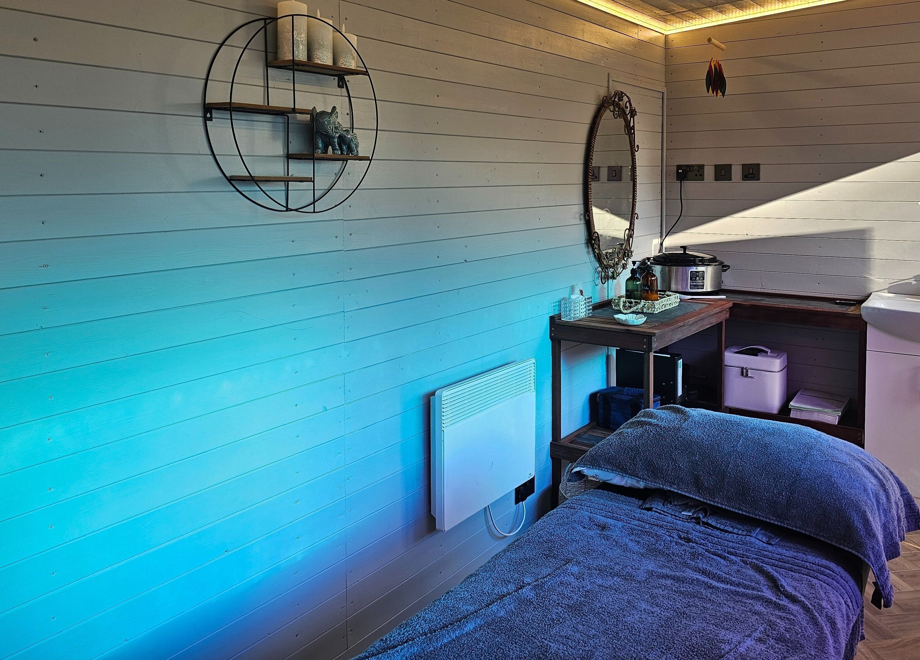 Relaxing massage room at Jem Stones Holistic Massage in Swindon, England, GB, featuring soothing blue tones.