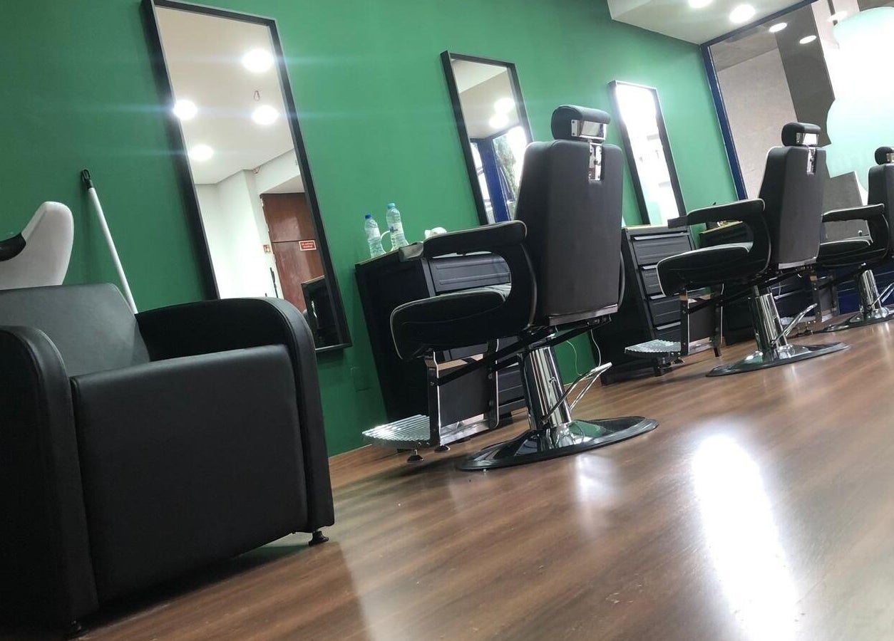 Interior moderno da Barbearia Arf'S em Porto, Porto, PT, com cadeiras de couro e espelhos elegantes.