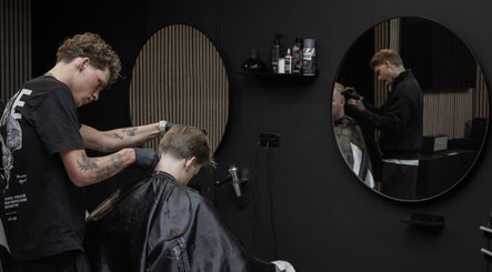 Kapper bezig met knippen bij James Barbershop, Spijkenisse, Zuid-Holland, NL.