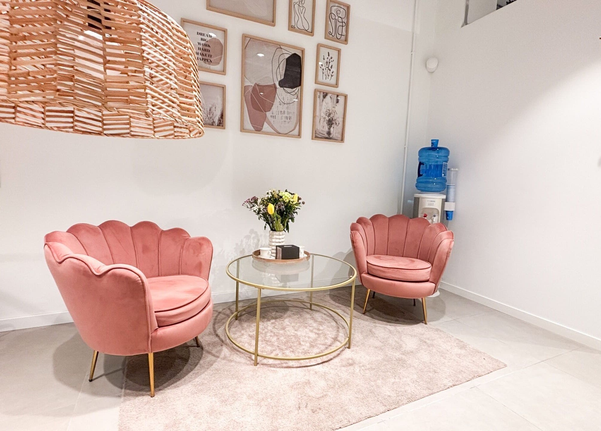 Acogedora sala de espera en Premier Experience, Barcelona, Catalunya, ES con sillones rosas y decoración moderna.