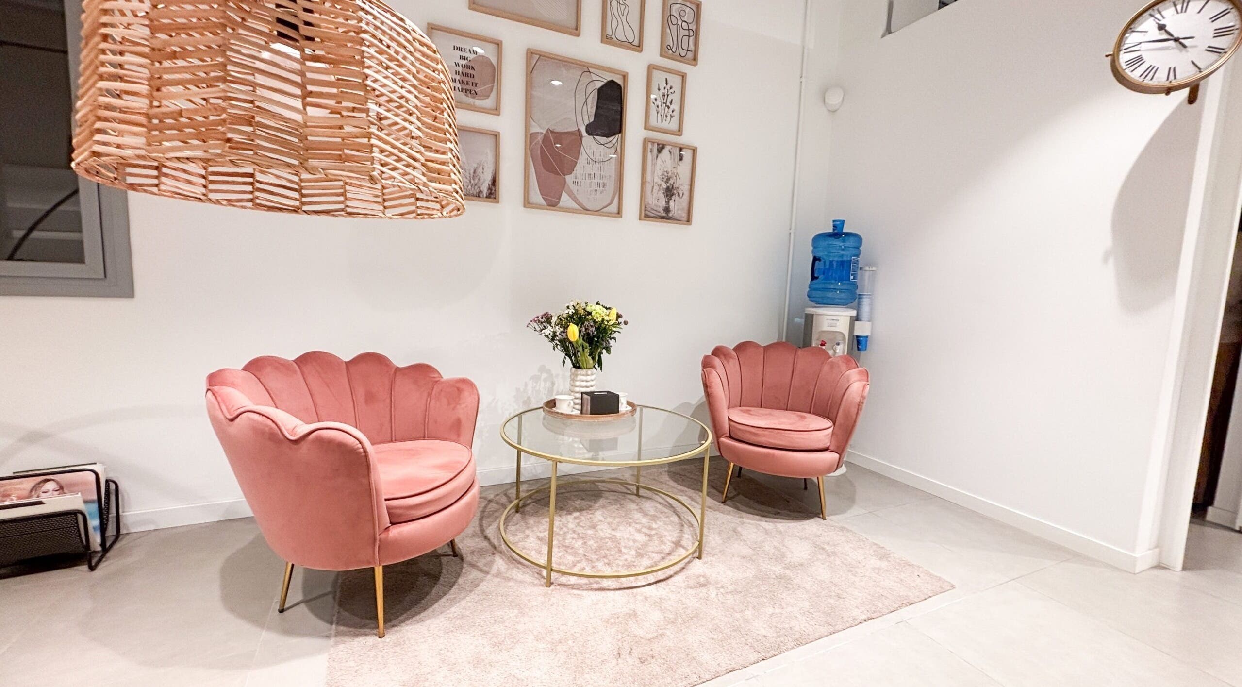 Acogedora sala de espera en Premier Experience, Barcelona, Catalunya, ES con sillones rosas y decoración moderna.